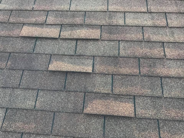 Inspecting shingles that have been lifted due to high winds.